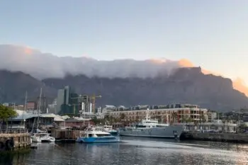 Cape town waterfront at sunset, South Africa. Yachts at harbor, Clouds over Table mountain summit