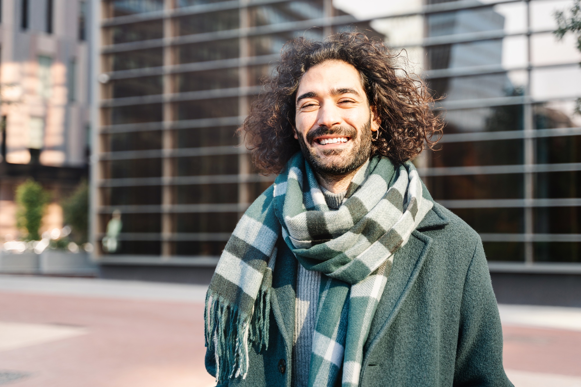Portrait of young stylish Italian or Spanish professional man with long curly hair