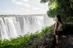 Young female tourist looking out at Victoria Falls, Zimbabwe, Africa