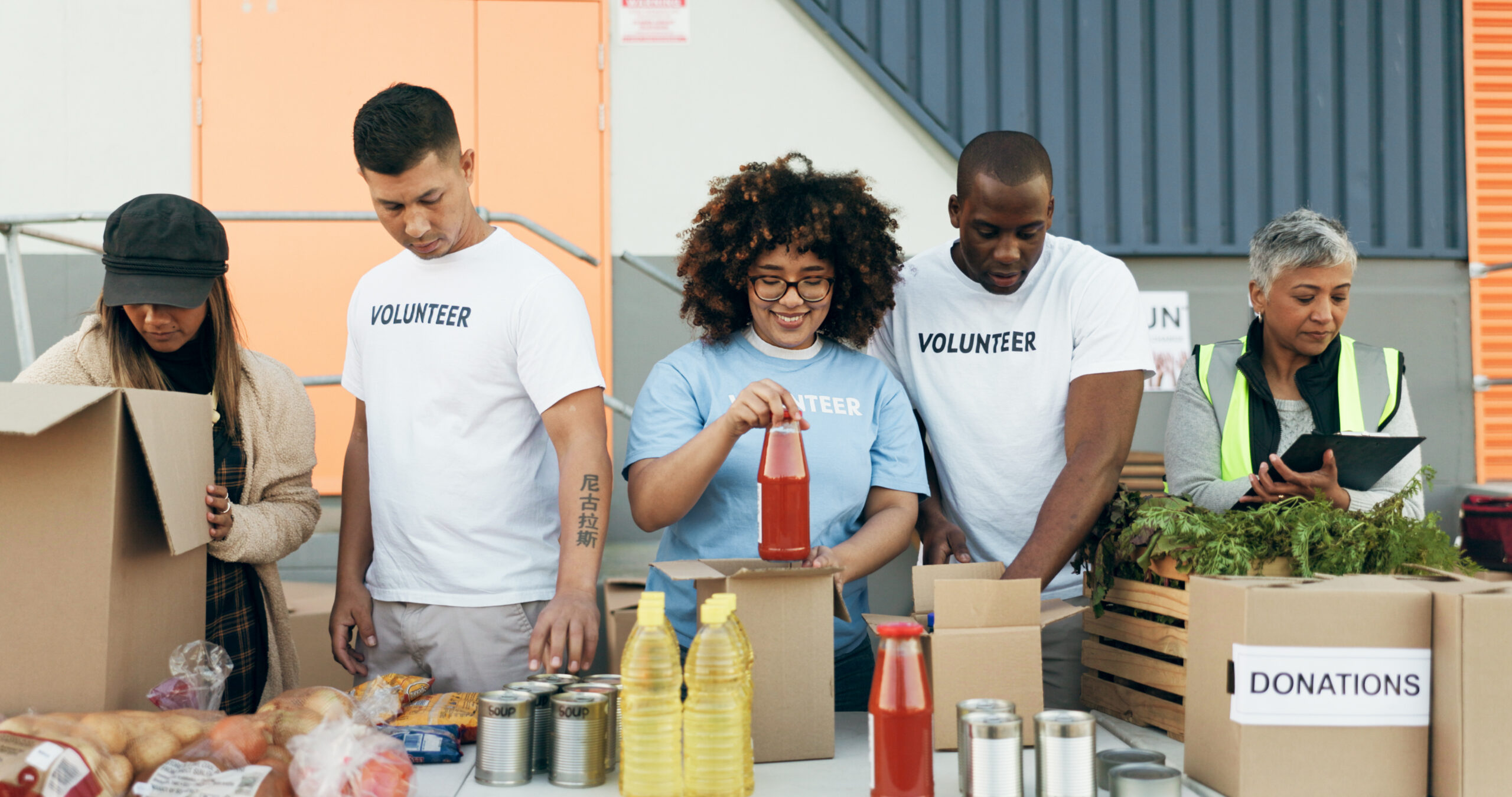 Group of people, volunteering and groceries on table for charity event with care, kindness and help.