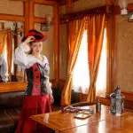 beautiful girl in steampunk costume in an old train carriage close-up