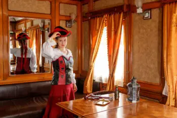 beautiful girl in steampunk costume in an old train carriage close-up