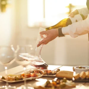 Mid section portrait of professional sommelier pouring wine while preparing for wine tasting session in sunlight, copy space
