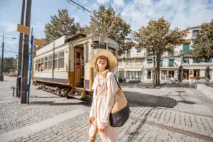 Lifestyle portrait of a woman near the famous old touristic tram on the street in Porto city, Portugal