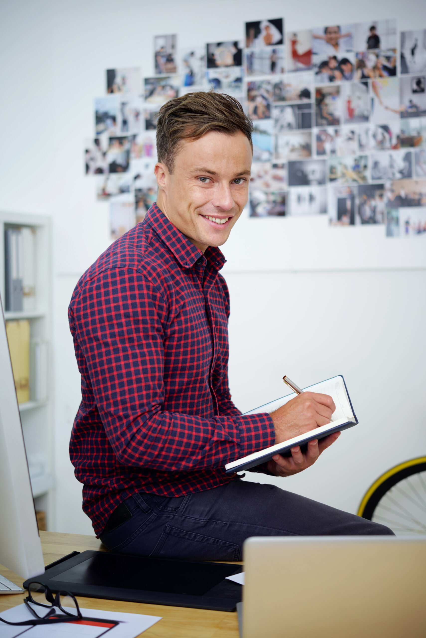 Smiling handsome businessman taking notes in his notepad